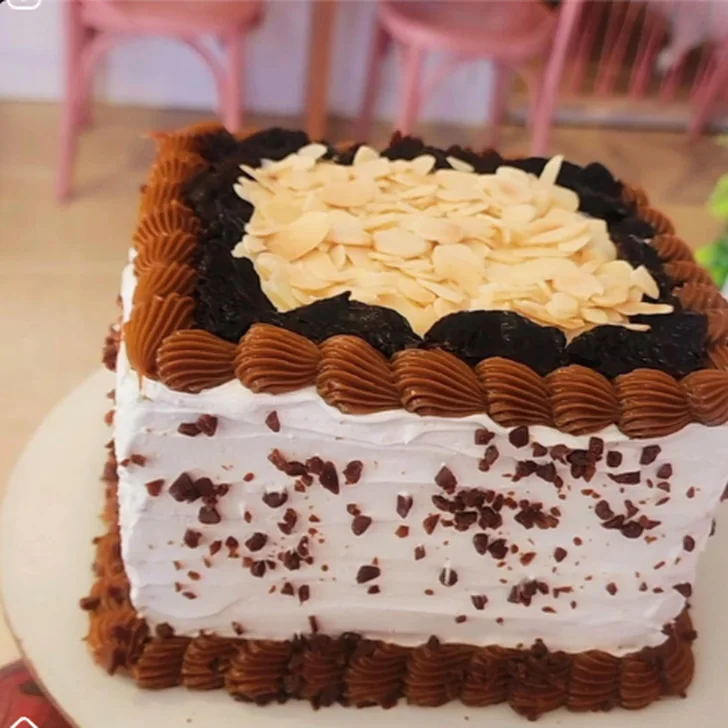 Bolo coberto com chantilly, ganache e lâminas de amêndoas
