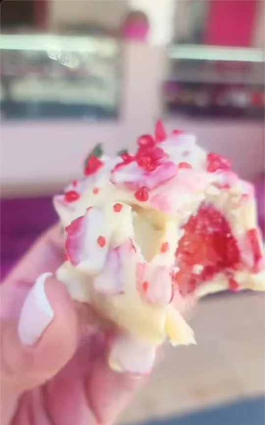 Bombom de chocolate branco com frutas vermelhas, mordido